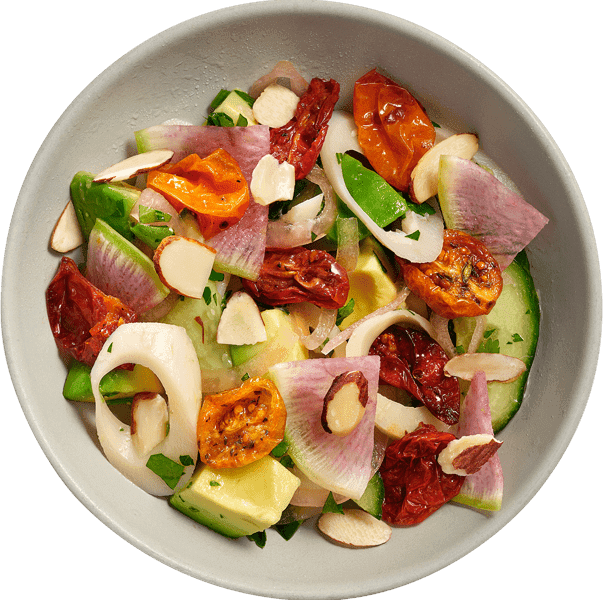 Hearts Palm Salad in reusable dish celebrates  local seasonal ingredients like tomato, red onion, avocado, almonds and herbs. 